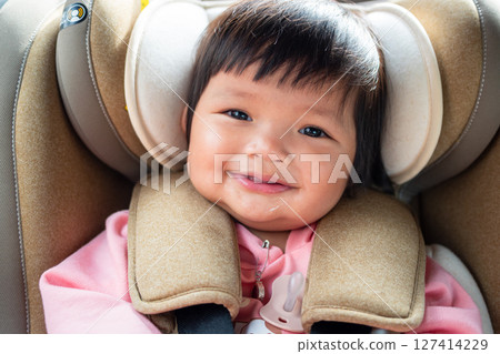Joyful one year old asian girl smiling in car seat lifestyle moment bright environment Joyful one year old asian girl smiling in car seat lifestyle moment bright environment 127414229