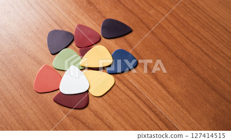 Colorful guitar picks arranged wooden surface artistic still life creative space close-up view Colorful guitar picks arranged wooden surface artistic still life creative space close-up view 127414515