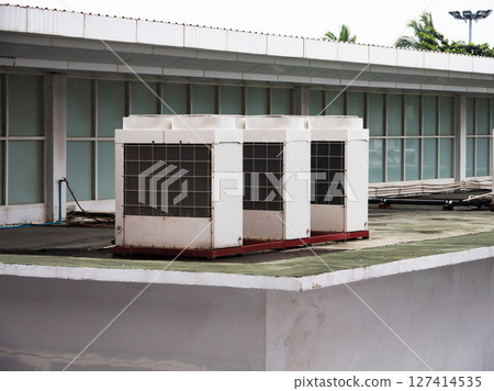 Industrial air conditioning units rooftop urban environment overcast sky 127414535