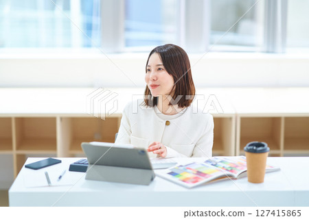 A woman in a suit working indoors A woman in a suit working indoors 127415865