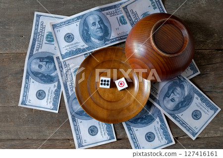 Dice on a wood plate with US bank note . Dice on a wood plate with US bank note . 127416161