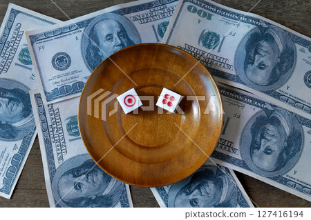 Dice on a wood plate with US bank note . Dice on a wood plate with US bank note . 127416194