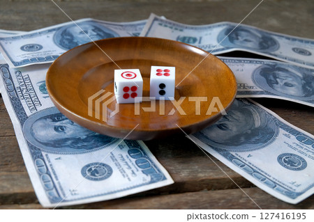 Dice on a wood plate with US bank note . Dice on a wood plate with US bank note . 127416195