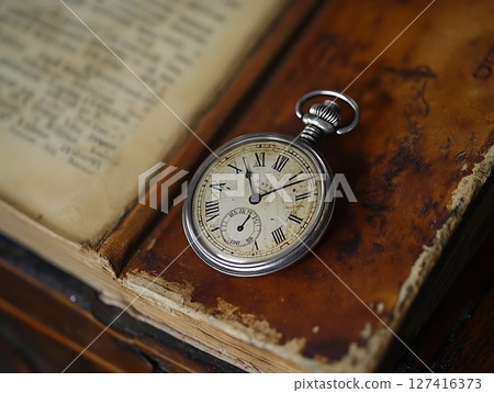 Antique Pocket Watch on Rustic Open Book Background 127416373