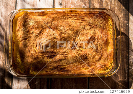 Glass platter with a meat or shepherd's pie on a rustic country table. 127416639