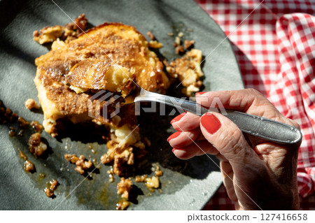 Woman's Hand cutting a homemade shepherd's pie freshly baked. Woman's Hand cutting a homemade shepherd's pie freshly baked. 127416658