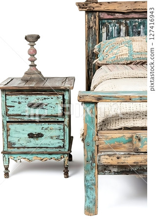 A bed with a blue headboard and a wooden nightstand with a candle on top 127416943