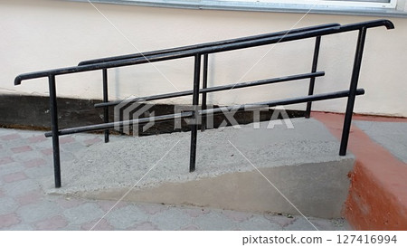 Handrails for grabbing when climbing ramp for people with disabilities. Creating comfortable entrance with care for people with mobility problems. Ramp for strollers and wheelchairs. Handrails for grabbing when climbing ramp for people with disabilities. Creating comfortable entrance with care for people with mobility problems. Ramp for strollers and wheelchairs. 127416994