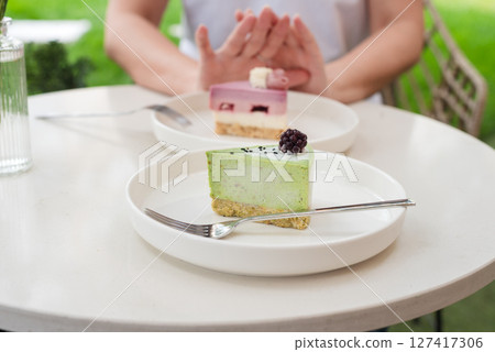 Woman Gesturing Near Colorful Cakes on White Plates in Outdoor Setting. No to sugar, diet concept, fasting, dieting, losing weight. No cakes, woman on a diet. Woman Gesturing Near Colorful Cakes on White Plates in Outdoor Setting. No to sugar, diet concept, fasting, dieting, losing weight. No cakes, woman on a diet. 127417306