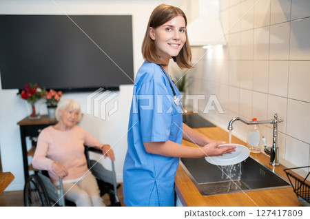 Care assistant cleaning the kitchen after breakfast Care assistant cleaning the kitchen after breakfast 127417809