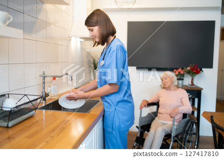 Care assistant cleaning the kitchen after breakfast Care assistant cleaning the kitchen after breakfast 127417810