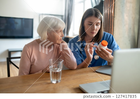 Care assistant reading instruction for a new medicine 127417835