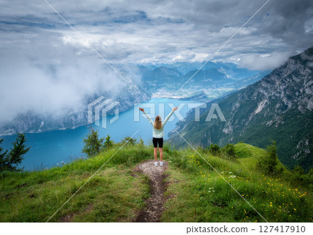 Young woman on the trail on mountain peak and lake 127417910