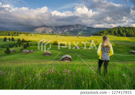 Young woman on the meadow with yellow flowers and green grass Young woman on the meadow with yellow flowers and green grass 127417955