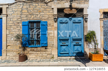Blue door and window shutters adding charm to traditional stone house Blue door and window shutters adding charm to traditional stone house 127418055