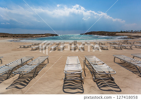 Empty sunbeds inviting tourists on sandy beach in cyprus 127418058