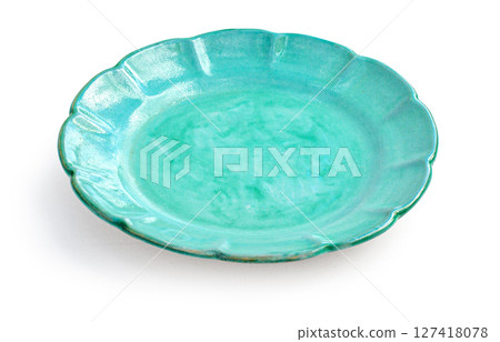 Empty green ceramic plate with wavy edges on white background Empty green ceramic plate with wavy edges on white background 127418078