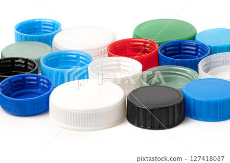 Colorful plastic bottle caps forming a pattern on white background Colorful plastic bottle caps forming a pattern on white background 127418087