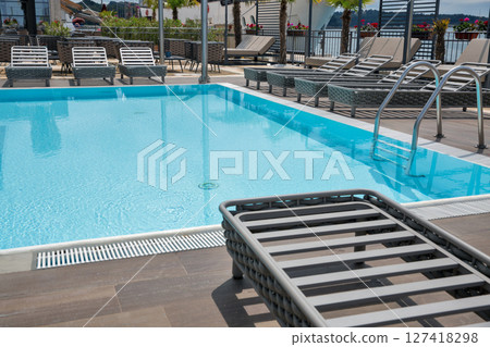 Empty swimming pool with sea view and sun loungers. Empty swimming pool with sea view and sun loungers. 127418298
