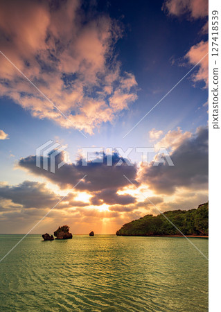 A moving sunset in Ishigaki Island with rays of light spreading out. Beautiful evening glow A moving sunset in Ishigaki Island with rays of light spreading out. Beautiful evening glow 127418539