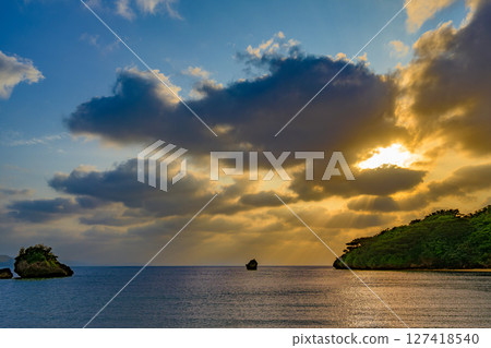 A moving sunset in Ishigaki Island with rays of light spreading out. Beautiful evening glow A moving sunset in Ishigaki Island with rays of light spreading out. Beautiful evening glow 127418540