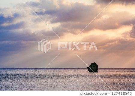 A moving sunset in Ishigaki Island with rays of light spreading out. Beautiful evening glow 127418545