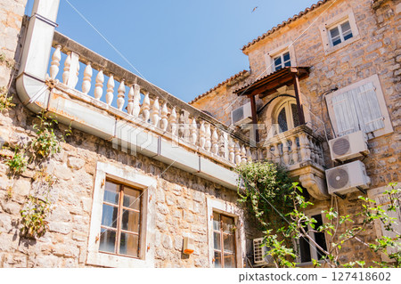 Historic stone building with classic balustrade and rustic charm. Mediterranean architecture, cultural heritage, and everyday European beauty. Historic stone building with classic balustrade and rustic charm. Mediterranean architecture, cultural heritage, and everyday European beauty. 127418602