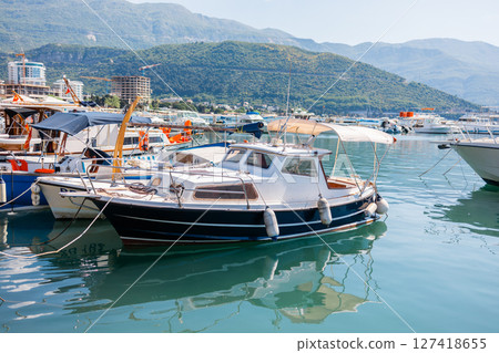 Luxury motor yacht docked at marina. Coastal lifestyle, leisure boating, and maritime tourism in summer harbor scene. Luxury motor yacht docked at marina. Coastal lifestyle, leisure boating, and maritime tourism in summer harbor scene. 127418655