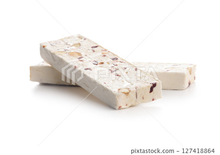White nougat bars with almonds and dried fruit isolated on white background. White nougat bars with almonds and dried fruit isolated on white background. 127418864