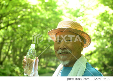 An old man hydrating in a mountain stream An old man hydrating in a mountain stream 127419400