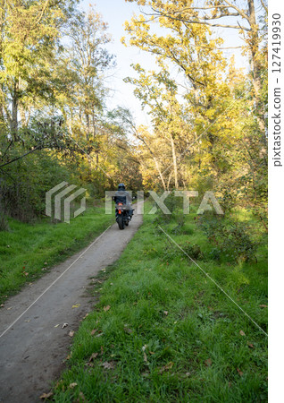A person riding a motorcycle down a dirt road 127419930