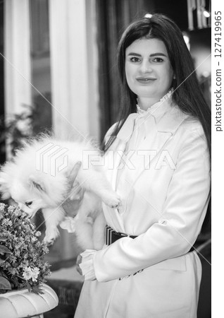 girl smiling and holding a small white spitz dog in her arms girl smiling and holding a small white spitz dog in her arms 127419965