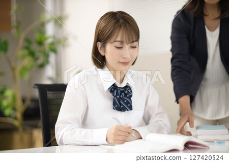A high school girl and her teacher studying 127420524