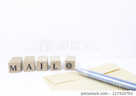 寫有 MAIL@ 的木塊,棕色信封,白色背景 寫有 MAIL@ 的木塊,棕色信封,白色背景 127420763