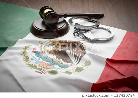 Gavel and Handcuffs Resting on a Tattered and Dirty Mexican Flag. Gavel and Handcuffs Resting on a Tattered and Dirty Mexican Flag. 127420784