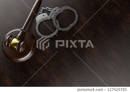 Gavel and Handcuffs on a Wooden Desk or Table Surface with Room for Copy. 127420785