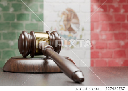 Wooden Gavel Resting on Table In Front of A Brick Wall with Mexican Flag. Wooden Gavel Resting on Table In Front of A Brick Wall with Mexican Flag. 127420787