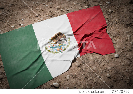 Tattered and DIrty Mexican Flag Laying in the Dirt. Tattered and DIrty Mexican Flag Laying in the Dirt. 127420792