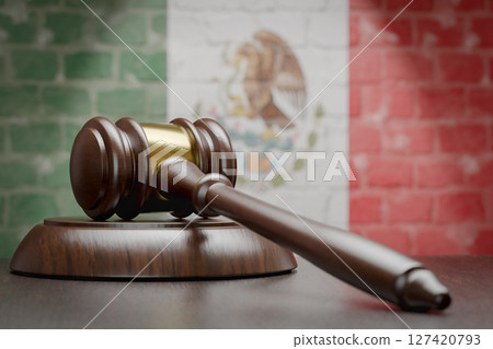 Wooden Gavel Resting on Table In Front of A Brick Wall with Mexican Flag. Wooden Gavel Resting on Table In Front of A Brick Wall with Mexican Flag. 127420793
