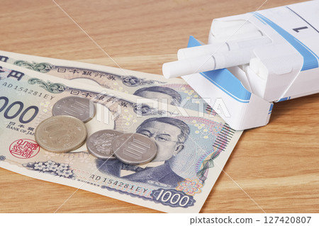 Money and cigarettes with an awareness of tax increases and cigarette prices Money and cigarettes with an awareness of tax increases and cigarette prices 127420807