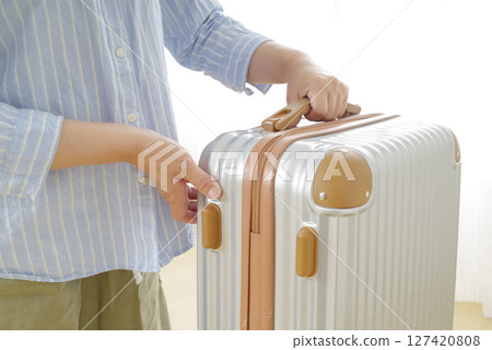 Senior woman's hand holding a travel bag Senior woman's hand holding a travel bag 127420808