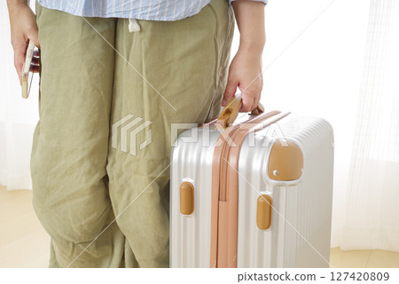Senior woman's hand holding a travel bag Senior woman's hand holding a travel bag 127420809