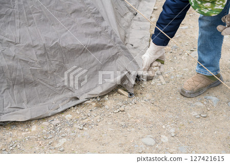 [Auto camping on the Nakatsugawa riverbed, removing the pegs from the tent skirt and preparing to withdraw] 127421615