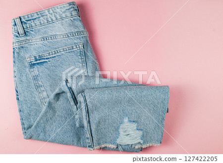 Stylish ripped denim jeans on pink background Stylish ripped denim jeans on pink background 127422205