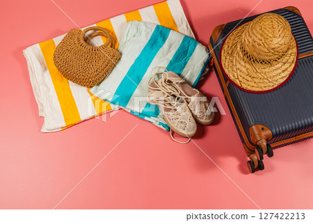 Packing for a beach vacation with essentials on colorful backdrop Packing for a beach vacation with essentials on colorful backdrop 127422213