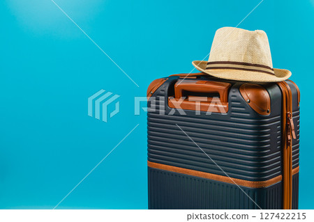 Summer travel essentials include suitcase and hat 127422215