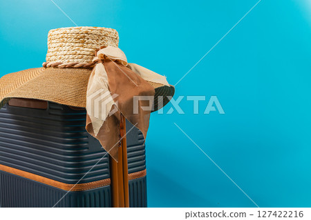 Summer travel essentials include a stylish hat and suitcase Summer travel essentials include a stylish hat and suitcase 127422216