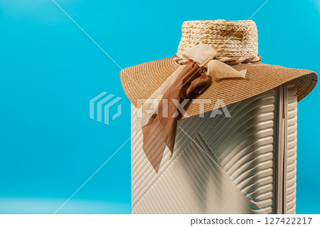 Stylish sun hat displayed against a vibrant blue background Stylish sun hat displayed against a vibrant blue background 127422217