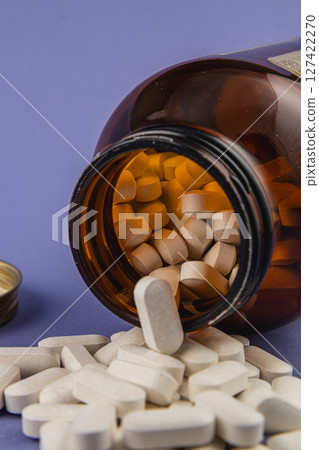 Bottled supplements spill onto a surface in clear view Bottled supplements spill onto a surface in clear view 127422270
