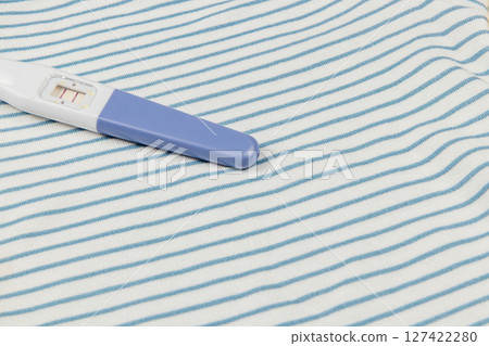 Pregnancy test on a striped fabric background Pregnancy test on a striped fabric background 127422280